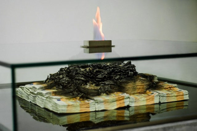 This Coffee Table Features Burning Stacks of Cash