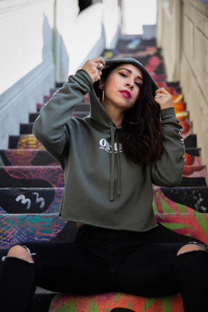 Women's olive crop top hoodie on a staircase in downtown Los Angeles